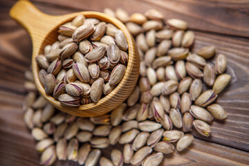 Pistachios in a Cup on a wooden background.  Place for text. Nuts close up