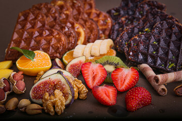 Waffles containing oranges, strawberries, kiwi, bananas, nuts, honey, cream, cocoa