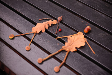 Craft from autumn leaves and acorns. The image of a man and a girl, couple.