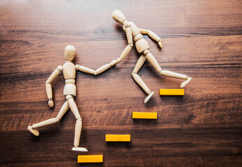 Helping hands. wooden figure holding hand person of  man and climb stairs. Concept idea, symbol of...