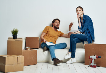 Man and woman in new room stuff in boxes moving family interior