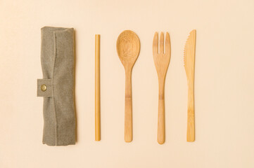 Set of Eco friendly bamboo cutlery on camel color background. Plastic free concept. Close-up, top...