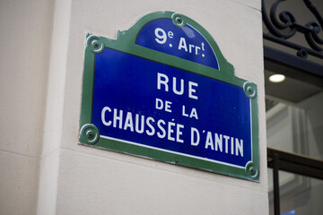 Closeup of Chaussee d'antin street name on the traditional parisian street plate on stoned building