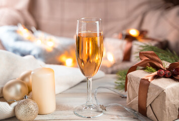 A glass of champagne on a Christmas background in a cozy atmosphere. The concept of a New year. Side view.