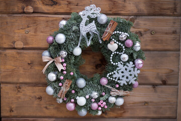 Beautiful Christmas wreath made of fir and Christmas toys on wooden