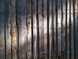 background old grunge wooden fence made of gray-brown boards in bright sunbeams