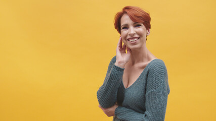 Portrait of red hair woman in her 40s isolated on yellow background. High quality photo