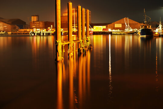  Tyres and rope hanging on metal post in Arklow harbour at night