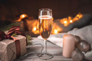 Evening Christmas background with a full glass of champagne on the background of a burning garland. The concept of New year and Christmas.