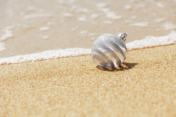 Christmas white glitter ball on the tropical beach near ocean, a summer Christmas and winter holyday concept. Merry Christmas and Happy New Year background,