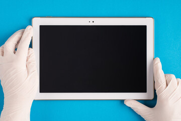 Top above overhead pov first person close up view photo of therapist physician hands in latex white gloves holding use modern technology gadget device watch presentation isolated blue background table