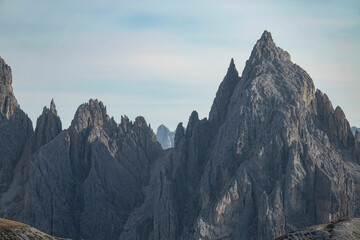 CLOSE UP: Rocky mountain peaks of Tre Cime tower into the clear blue fall skies. - obrazy, fototapety, plakaty