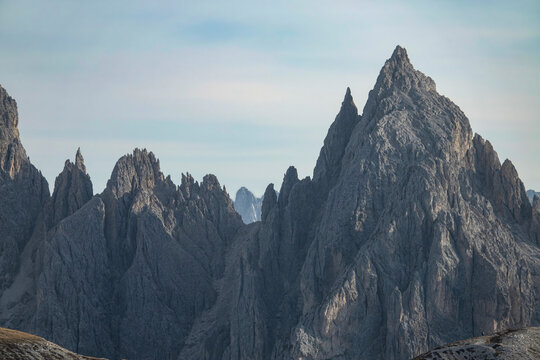 CLOSE UP: Rocky mountain peaks of Tre Cime tower into the clear blue fall skies.