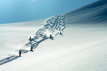 A group of heli skiers come down the mountain