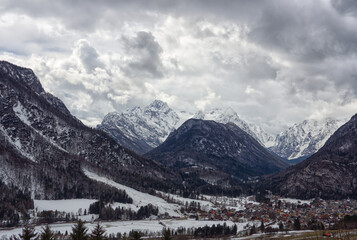 Slovenian Alpine village of Mojstrana on a stormy winters day with Triglav mountains behind