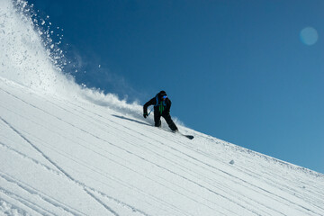 A snowboarder riding fresh powder snow
