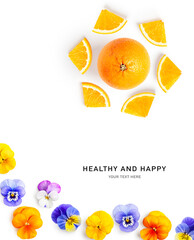 Orange citrus fruit and pansy flowers creative layout.
