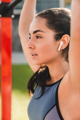 Close up photo of young female jogger with earphones on the sporting ground
