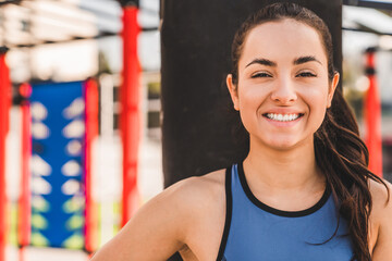 Cheerful smiling young woman athlete standing with puch bag behind on the sports ground © InsideCreativeHouse