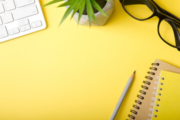 Yellow desk office with laptop, smartphone and other work supplies with cup of coffee. Top view...