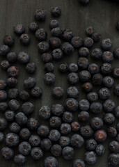 Fresh blueberries displayed on a wooden dark background.