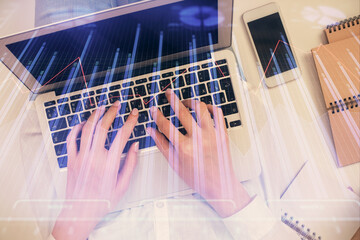 Double exposure of woman hands working on computer and forex chart hologram drawing. Top View. Financial analysis concept.