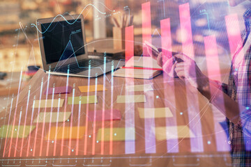 Double exposure of woman hands working on computer and forex graph hologram drawing. Financial analysis concept.