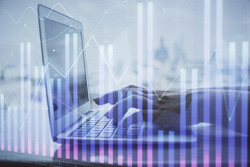 Fototapeta premium Double exposure of woman hands typing on computer and forex chart hologram drawing. Stock market invest concept.
