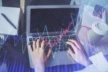 Double exposure of woman hands typing on computer and forex chart hologram drawing. Stock market invest concept.