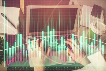 Double exposure of woman hands typing on computer and forex chart hologram drawing. Stock market invest concept.