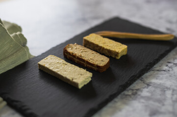 Different soy products on a slate plate. Firm tofu, smoked tofu and tempeh