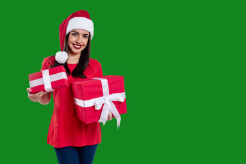 Woman with Christmas hat holding a gift, isolated on green background