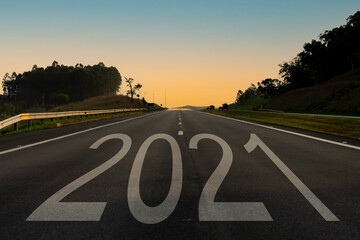 New Year 2021. Word 2021 written directly in the middle of the asphalt road, at the end of the day. Concept of planning and challenge or career plan, business strategy, opportunity and change.
