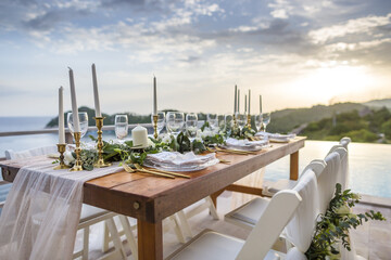 Romantic Wedding Table Top Layout Table Spread no people tropical location with gold cutlery and scenic view of sunset with copy space