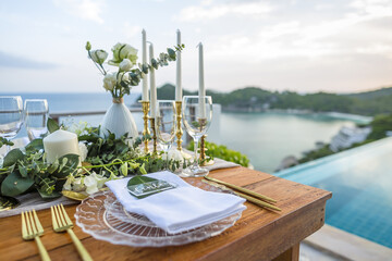 Romantic Wedding Table Top Layout Table Spread no people tropical location with gold cutlery and scenic view of sunset with copy space