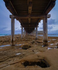 Under a wooden crossing bridge in La Perouse Sydney Australia on a cloudy dark rainy afternoon 