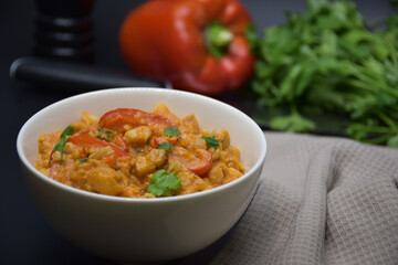 Brazilian fish stew cooked in a delicious, rich and fragrant broth, cilantro, napkin, pepper on a black background. 