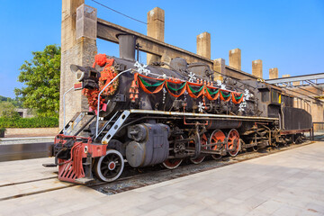 A steam locomotive with colorful festive decorations on the platform in a railway station.Festive or christmas background