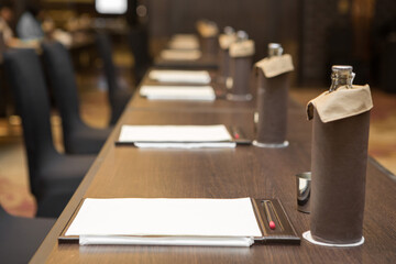 Paper, pencil, water bottle, glass on the table  in the seminar room background