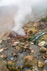Exciting view of volcanic landscape, erupting fumarole, aggressive hot spring, gas-steam activity in crater of active volcano. Dramatic mount landscape, travel destinations for active vacation, hike.