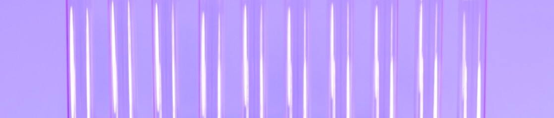 Glass tubes exhibited vertically on a purple background.