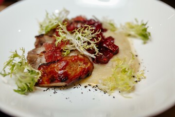 Grilled pork steak with green salad on a wooden table, top view