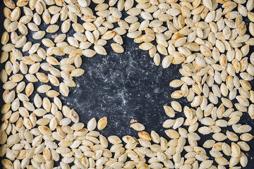 Closeup of freshly roasted and salted pumpkin seeds on a baking sheet
