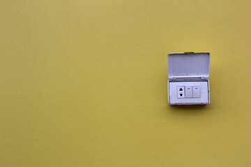 Light switches, light boxes, electrical sockets, 3 electrical outlets on the yellow cement floor...