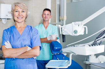 Female dentist standing in dental office with a hands crossed looking at camera