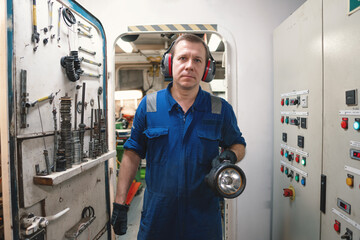 Marine engineer officer controlling vessel enginesand propulsion in engine control room ECR. Ship onboard maintenance