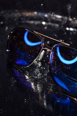 Sunglasses with blue lenses on a black background