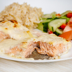 Baked salmon with vegetables and rice under cheese sauce