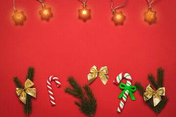 Red background with Christmas accessories and glowing garland.