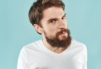 Obraz premium Model bearded man in white T-shirt on blue background irritability emotions model